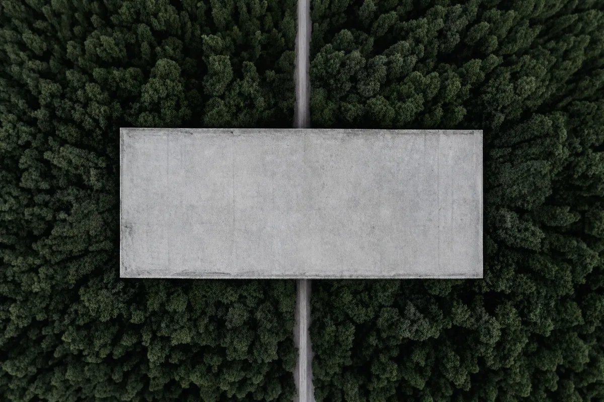 Aerial view of a concrete structure surrounded by forest